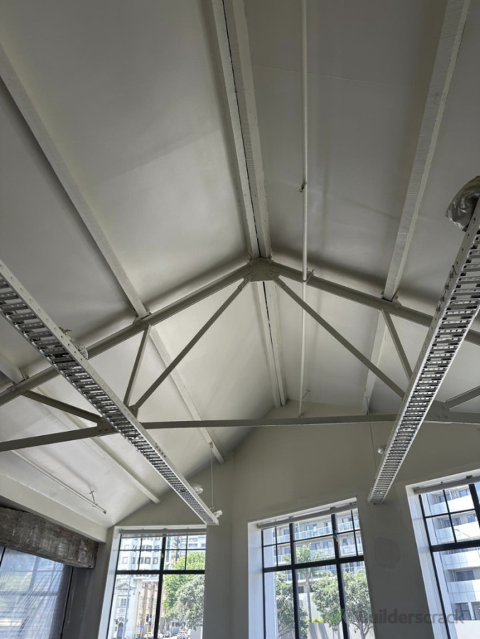 The final result. High-quality finish on the vaulted ceilings and steel beams, giving the space a bright and clean professional look.