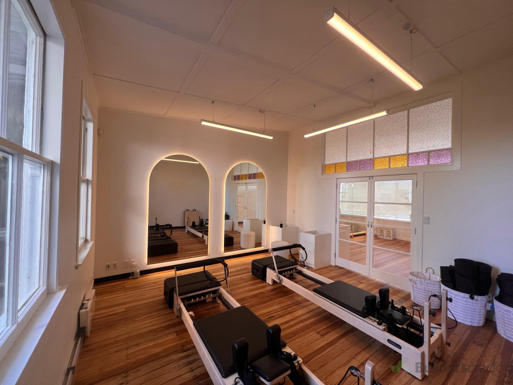 Yoga studio reno — new lighting with LED mirror halo strips for a calm glow.