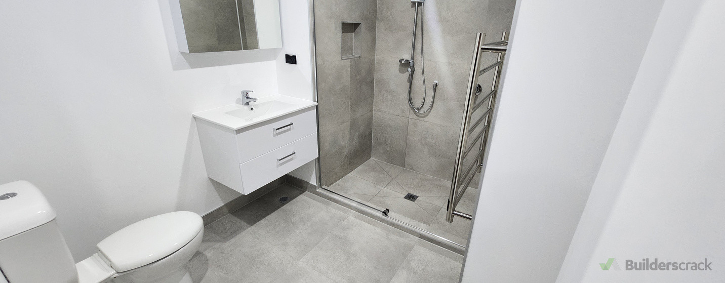 Completed bathroom plumbing installation – modern shower, vanity, and toilet fitted with a clean, professional finish.