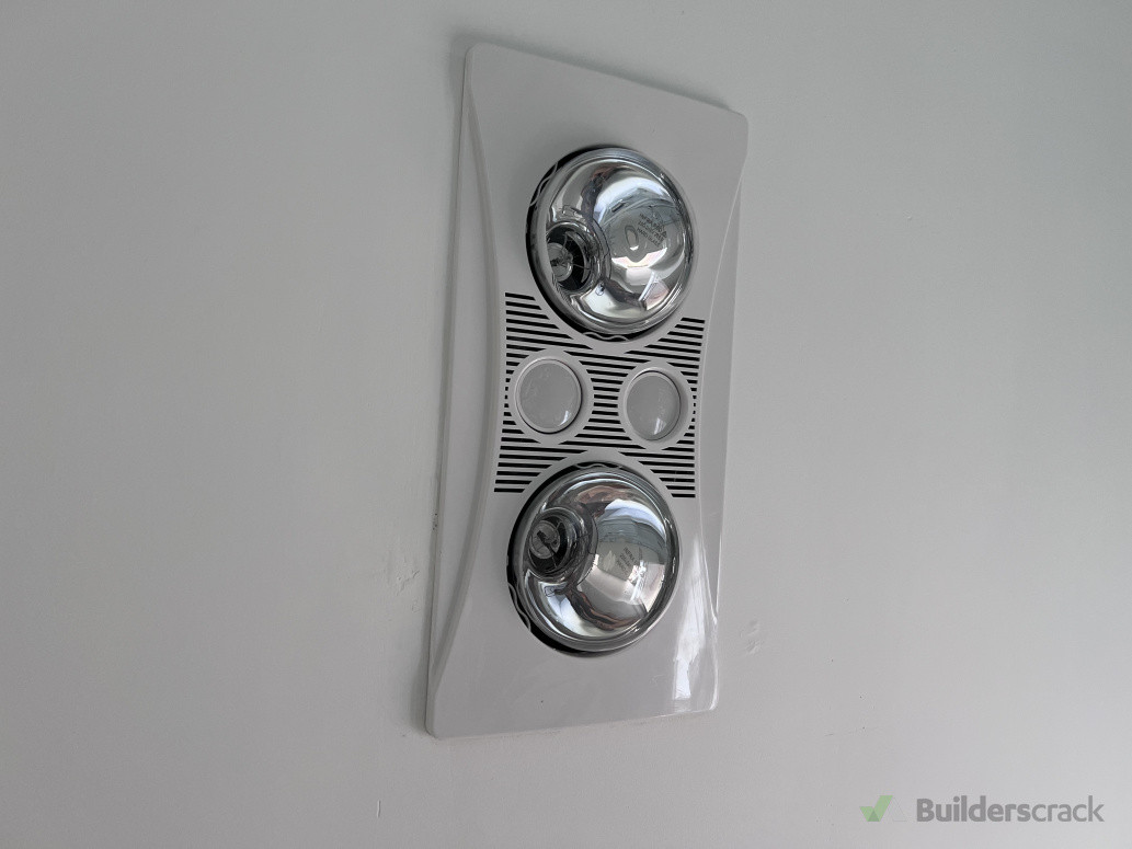 Ceiling-mounted bathroom heat lamp and extraction system installed to improve ventilation, reduce moisture buildup, and enhance thermal comfort.