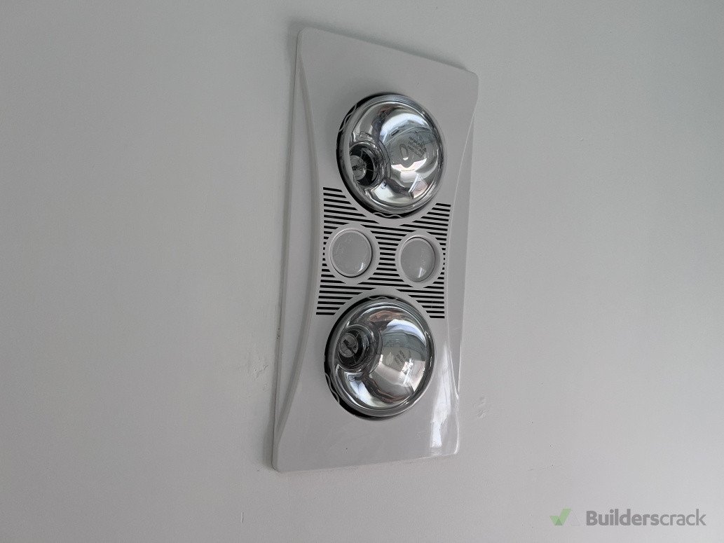 Ceiling-mounted bathroom heat lamp and extraction system installed to improve ventilation, reduce moisture buildup, and enhance thermal comfort.