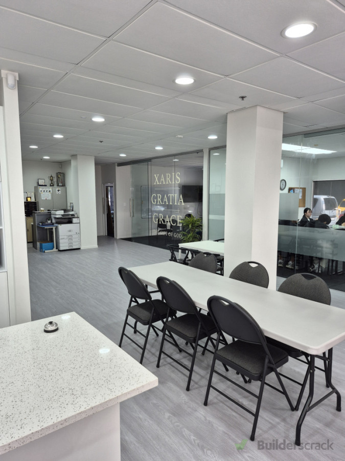 Finished interior space with meeting tables and kitchen facilities.