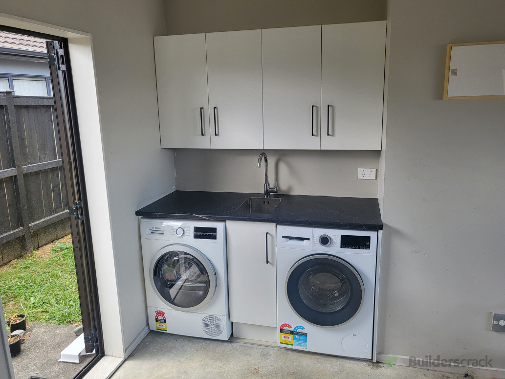 a narrow laundry with small tub
