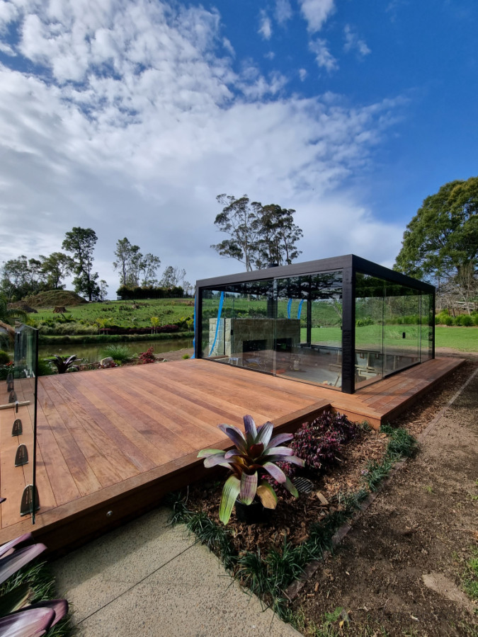 Outdoor sunken lounge area with custom made couch inside. New kwila deck wrapping around pergola