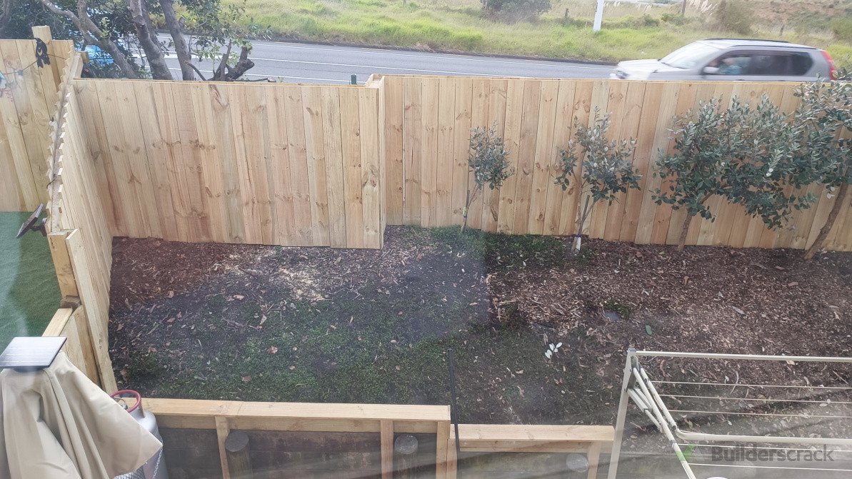 Build a privacy and noise barrier fence behind existing roadside metal fencing