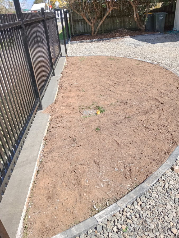 Lawn with curb edging and aggregate driveway.