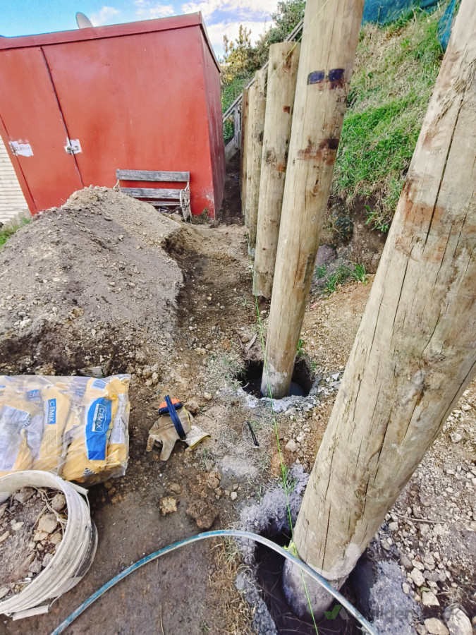 Holes dug, posts in, concrete mixed and poured. Excess dirt stored to the side for redistribution afterwards