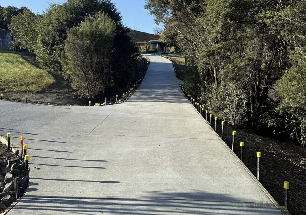 Steep driveway which had  access complications that we re-contoured and remediated with excavation, rock swales, and a top soil finish in Wainui.