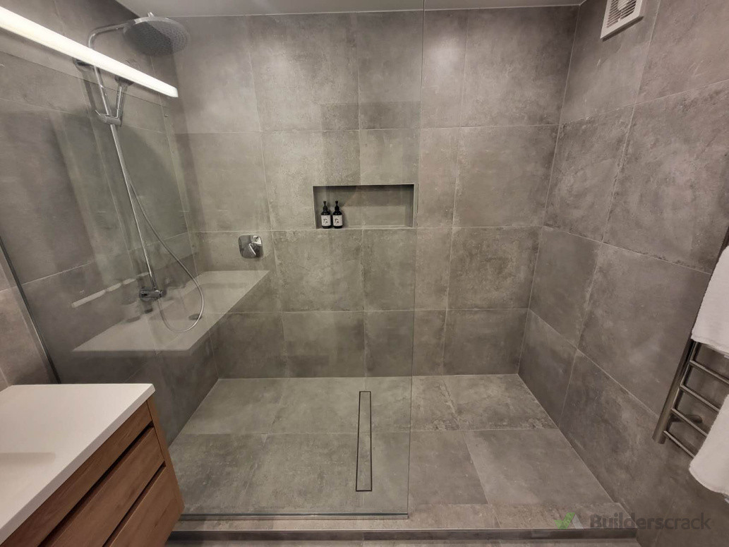 Bathroom was fully demolished.New Walk-in  tiled shower with curb on concrete base.Single shower glass panel. Shower drainage updated.