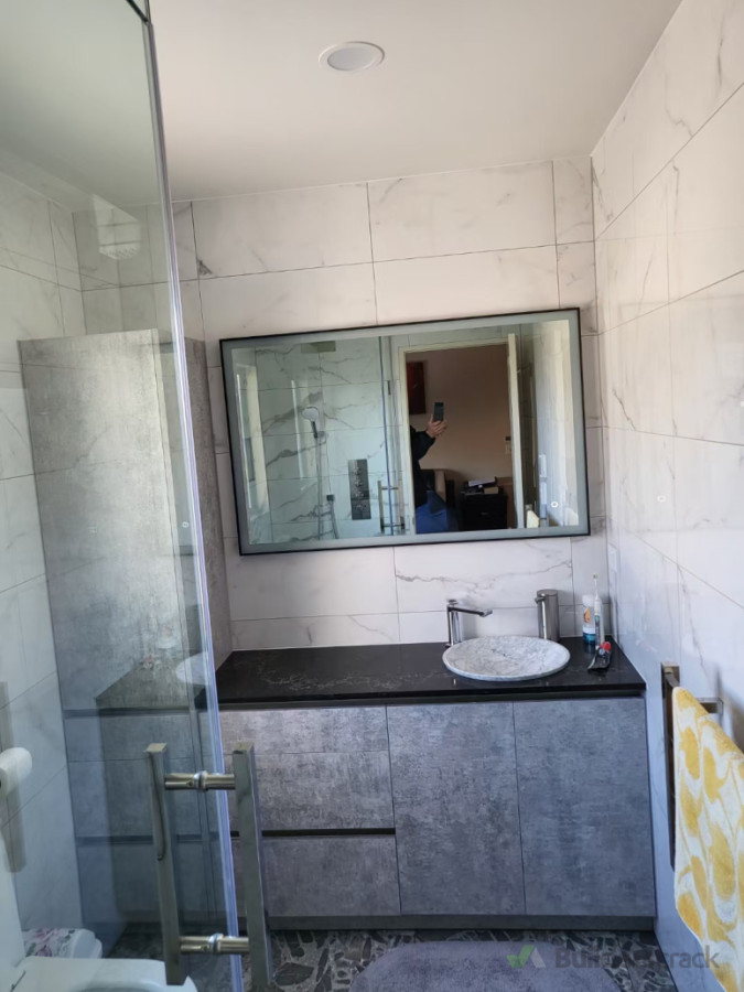 Fully demolished, custom made frame less shower enclosure to ceiling and vanity.