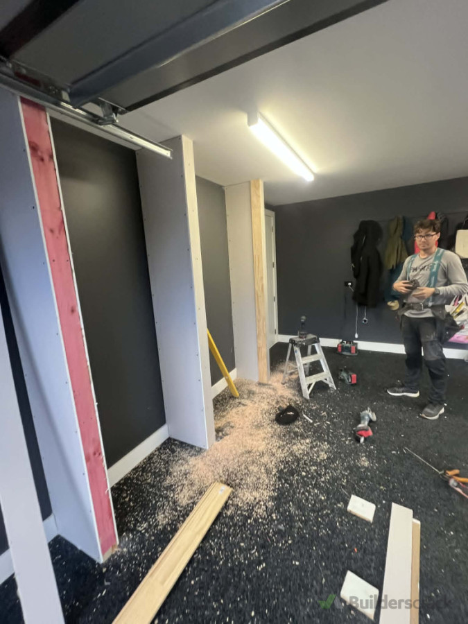 "Making a mess is part of the process—cleaning it up is our guarantee! Cade caught mid-build framing out some custom garage storage partitions."