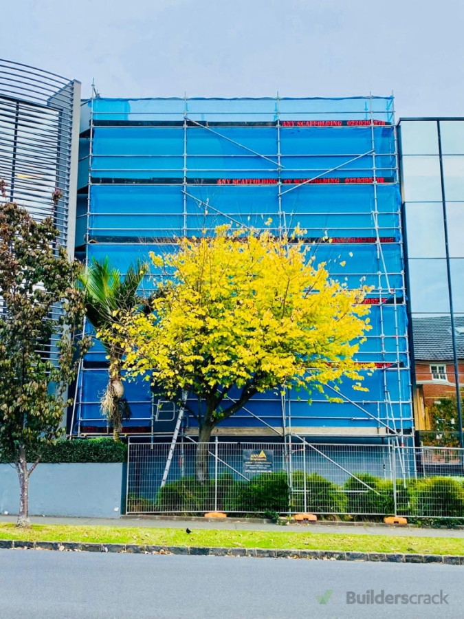Perimeter commercial scaffold with safety mesh.