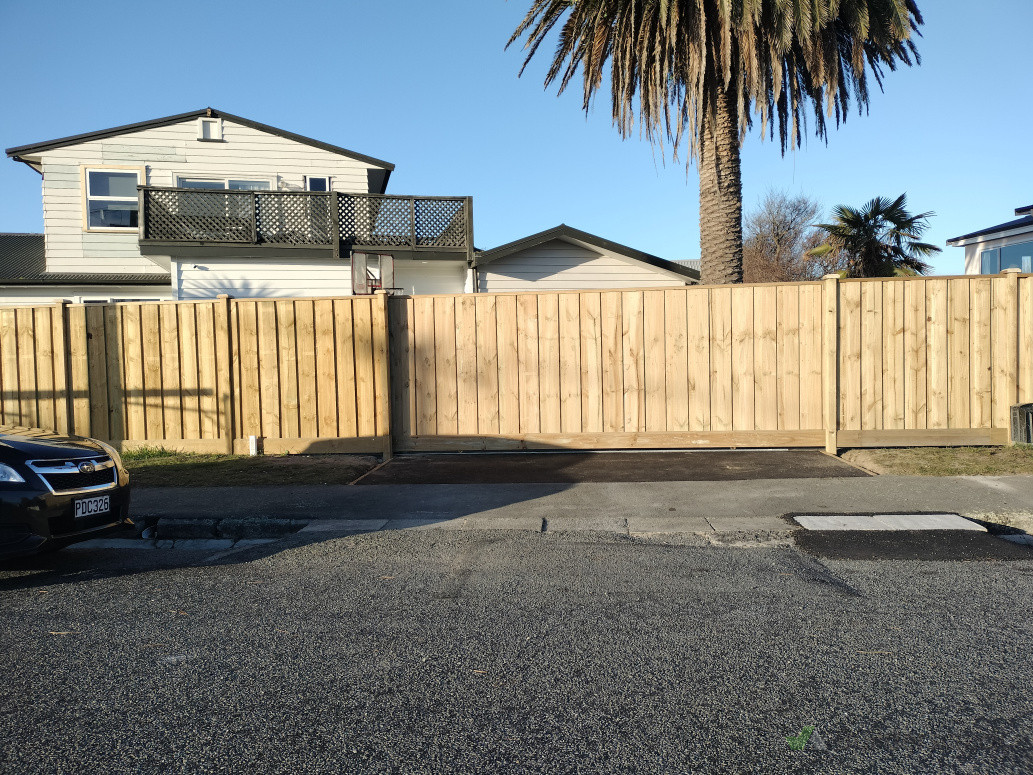Timber fence with Capping and Kickboard, exposed posts with post caps, Driveway gate with same fence profile and automatic opener.