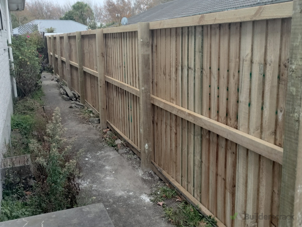 Standard post, rail and paling fence dividing two properties.