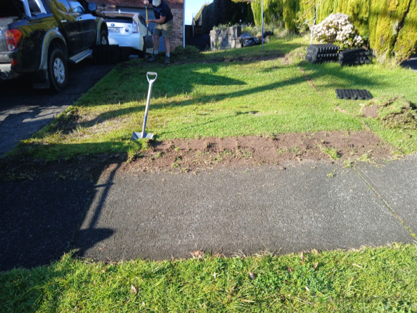 Remove grass and soil by hand due to rocks and services.