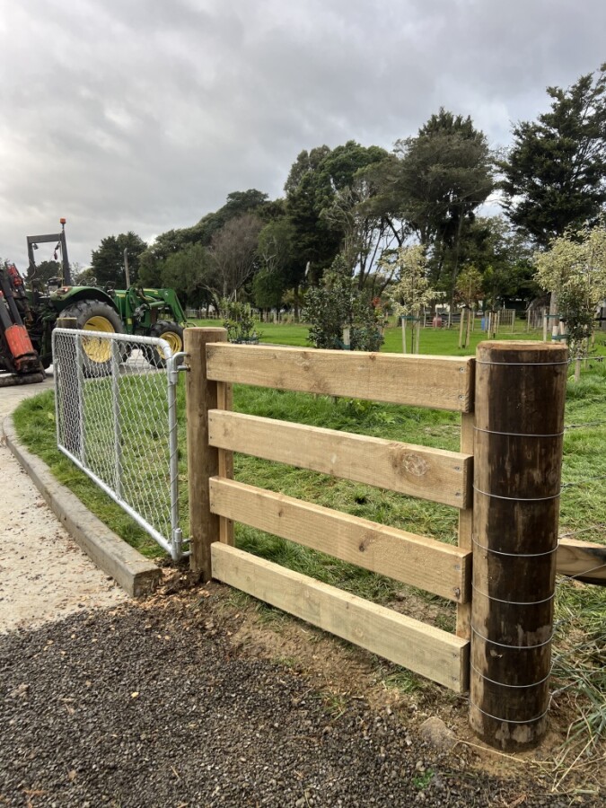Heavy-duty timber farm gate installation with quality post and rail construction.