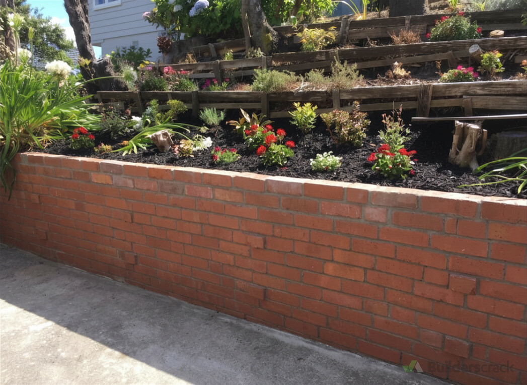 Dug back behind garden wall to tooth back failing areas, making sure that the wall was tied and structural.