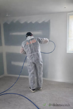 Interior spray painting in progress with surfaces and the surrounding area protected.