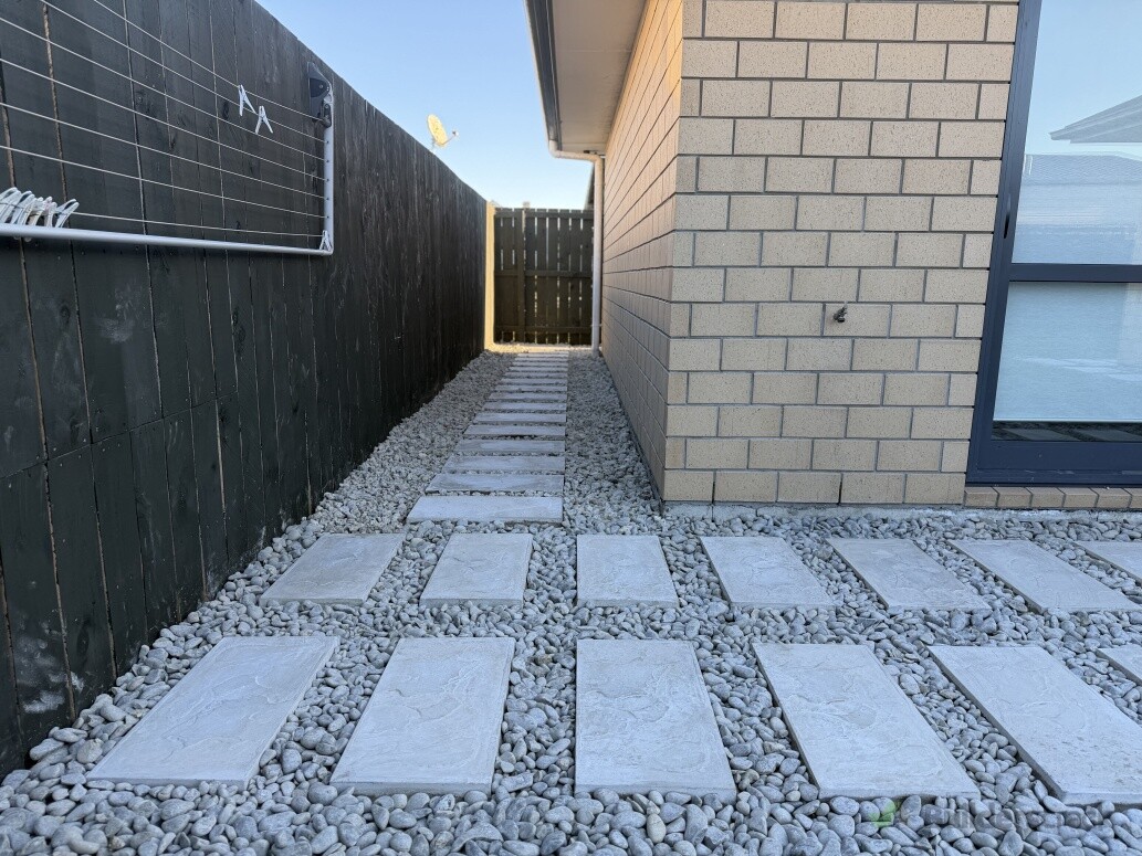 Paving & garden pathway in Hamilton & Waikato – modern stepping pavers with decorative white stones, creating a clean, low-maintenance outdoor space.