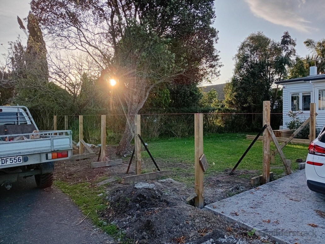 Picket fence going around front next to driveway extension
