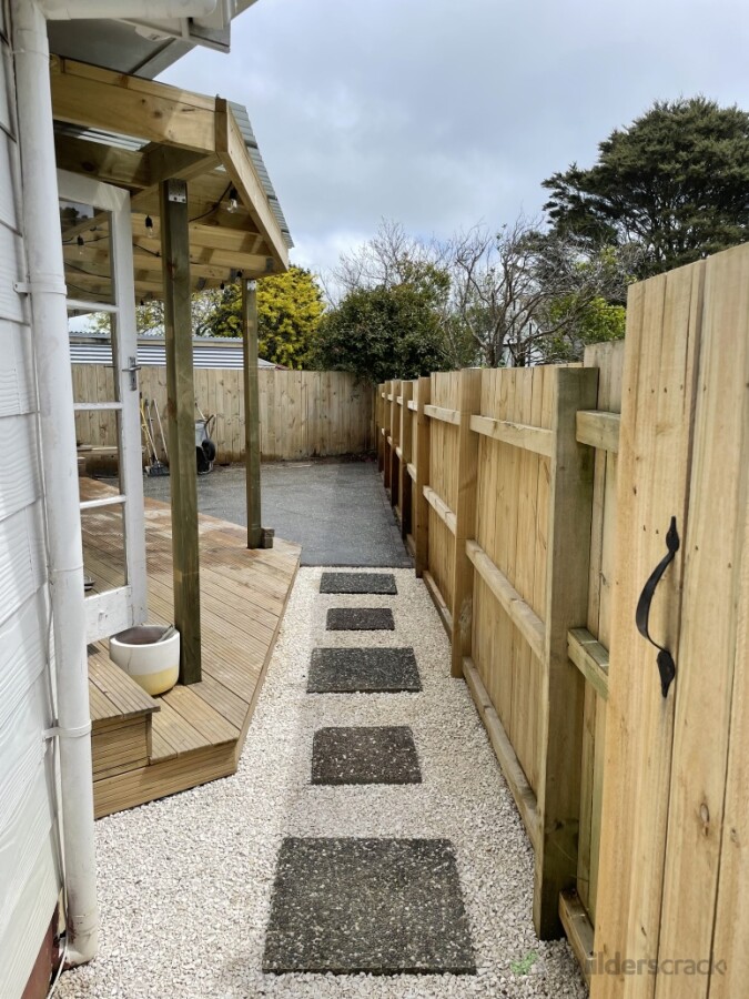Backyard exposed black oxide concrete with paving block walkway