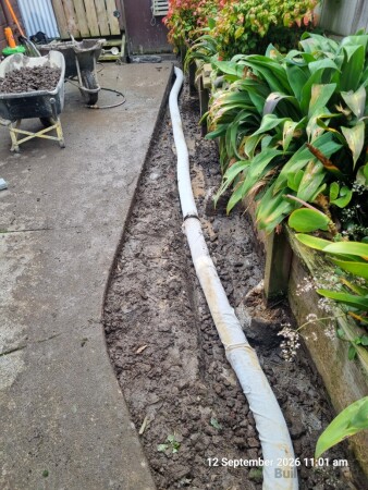 Coil installed on a bed of scoria and wrapped in filter sock