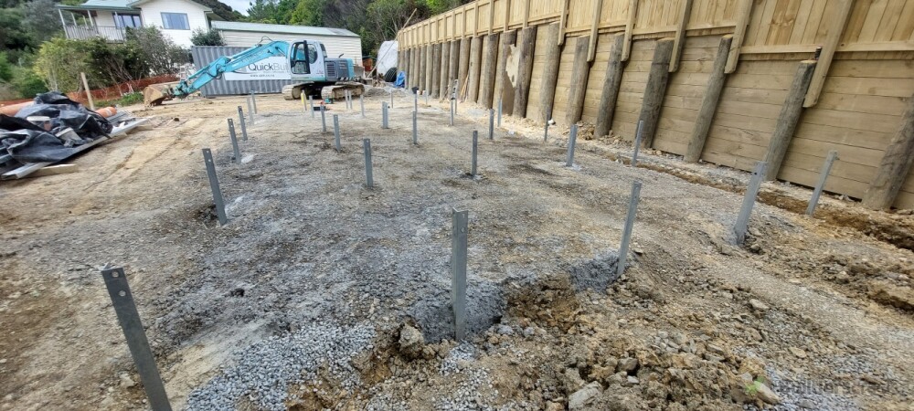 House piles in next to a retaining wall we built with a fence atop