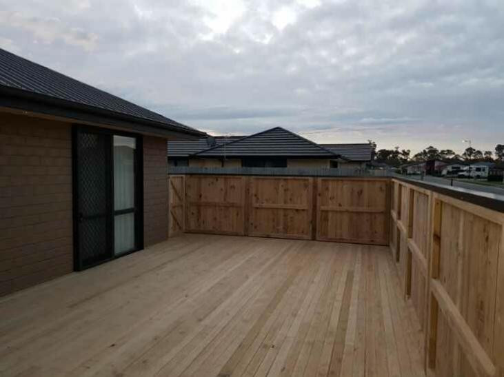 Dressed pailing fence with colour steel capping and pine deck