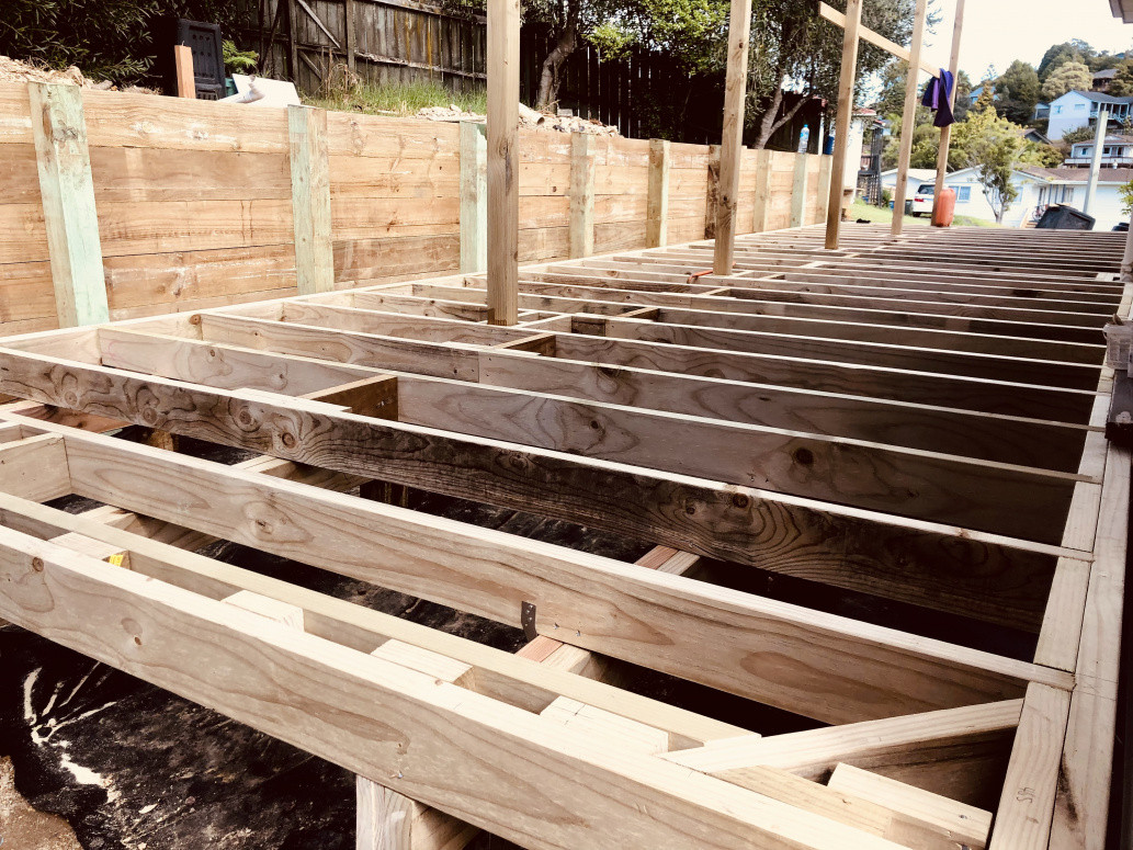 Deck framing with retaining wall