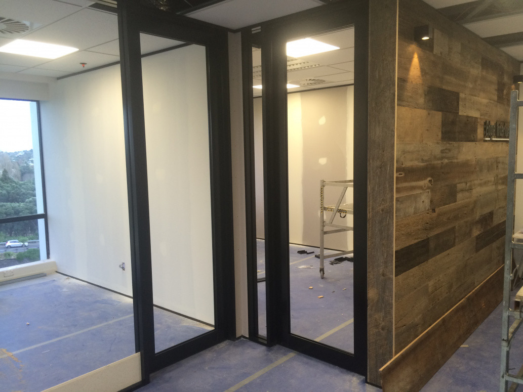 Edge Interiors fitout company's own office. Full height sound rated walls built from aluminium extrusion, steel stud framing, gib linings, aluminium  glazed doors fabricated and hung on site. Feature wooden wall built.