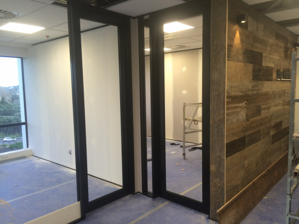 Edge Interiors fitout company's own office. Full height sound rated walls built from aluminium extrusion, steel stud framing, gib linings, aluminium  glazed doors fabricated and hung on site. Feature wooden wall built.